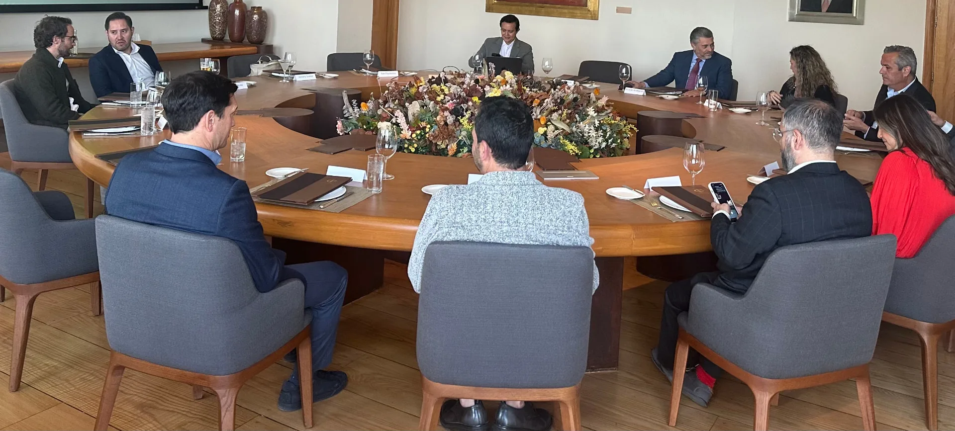 Vista amplia de la sala con los miembros sentados alrededor de la gran mesa redonda antes de la cena en la sesión inaugural de WRE Circle en la Ciudad de México